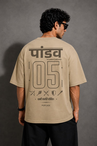 Model wearing a beige POPCASE 5 Pandav oversized t-shirt featuring a large graphic of 'Pandav' in Hindi, '05', and warrior icons. Premium streetwear. - beige