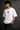 White oversized t-shirt with a bold graphic of the warrior Abhimanyu in front of a chariot wheel. Text includes "Made For War" and "Abhimanyuh" in Hindi. Detailed fabric information and care instructions are shown.