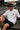 Model wearing white POPCASE Charles Leclerc Scuderia Ferrari oversized t shirt with prancing horse shield badge at F1 circuit pitlane