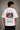 Man wearing a white CR7 oversized t-shirt with black CR7 logo. Studio shot with grey background.