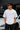 Model wearing white POPCASE George Russell Mercedes oversized t shirt with star logo on chest and teal MERCEDES race car back graphic