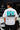 Model wearing white POPCASE George Russell Mercedes oversized t shirt with star logo on chest and teal MERCEDES race car back graphic