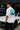 Model wearing white POPCASE George Russell Mercedes oversized t shirt with star logo on chest and teal MERCEDES race car back graphic