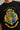 Black oversized t-shirt with the Hogwarts crest and 'Hogwarts' text in yellow, worn by a person. Features detailed coat of arms with lions, snakes, badgers, and eagles.