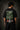 Man wearing a black Kalpvruksh oversized t-shirt with a colorful tree and bird graphic print on the back. Features Hindi script and 'The Wishing Tree' text. Streetwear style.