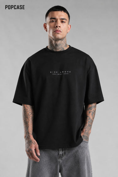 Black POPCASE LAUNCH oversized t-shirt featuring a large, distressed gray wing graphic print. Close-up on the premium fabric and detailed print for a streetwear aesthetic.