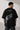 Black POPCASE LAUNCH oversized t-shirt featuring a large, distressed gray wing graphic print. Close-up on the premium fabric and detailed print for a streetwear aesthetic. - black