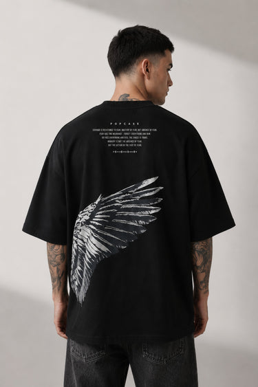 Black POPCASE LAUNCH oversized t-shirt featuring a large, distressed gray wing graphic print. Close-up on the premium fabric and detailed print for a streetwear aesthetic. - black