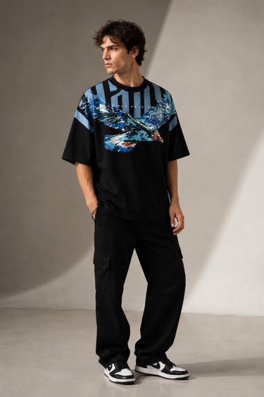 LAYERS black oversized t-shirt with a dynamic blue, white, and orange abstract graphic print, featuring "THE ONLY C" text detail, showcasing its premium fabric and streetwear aesthetic.