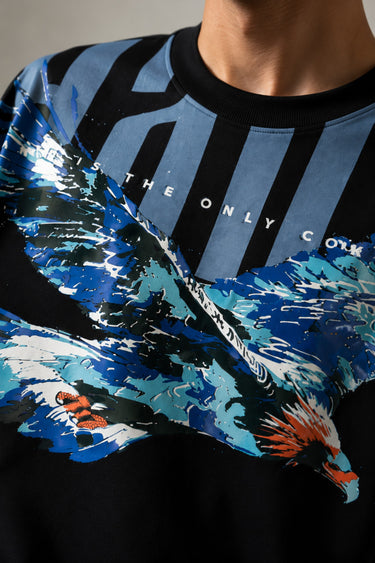 LAYERS black oversized t-shirt with a dynamic blue, white, and orange abstract graphic print, featuring "THE ONLY C" text detail, showcasing its premium fabric and streetwear aesthetic.