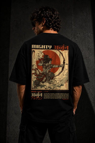 Black MIGHTY ARJUN oversized t-shirt featuring distressed Hindi script graphic in beige and orange, highlighting streetwear style.