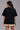 Black POPCASE oversized unisex tshirt with Conquer Yourself in layered red gothic and grey shadow text on front, styled with beige bubble shorts