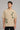 Back view of a man wearing a beige RARE INSIGHT oversized t-shirt with a green "Sorry But I Don't Care" graphic and star accents. - beige