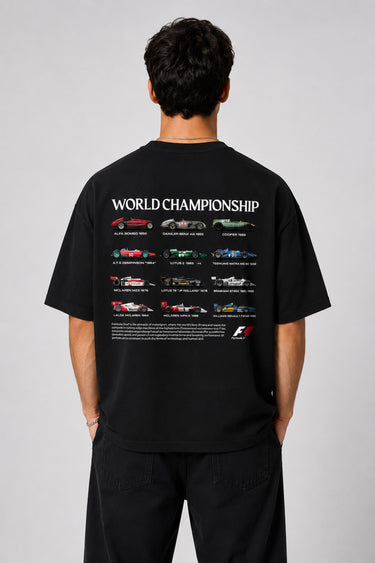 Model wearing a black oversized t-shirt with a small, embroidered Formula 1® logo in white, red, and gray on the chest. Casual streetwear style. - black