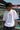Person wearing a white t-shirt with 'POPCASE' logo at a race track.