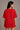 Woman wearing a red t-shirt against a plain background