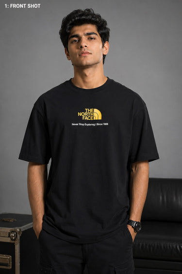 Man wearing FROM THE NORTH oversized t-shirt in beige with black cargo pants and white sneakers. Features The North Face logo and graphic on front and back.