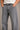 Person wearing gray jeans with a plain background