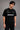 Black QUICKE oversized t-shirt featuring bold white graphic print on the chest and back. Showcasing premium fabric details and relaxed fit.