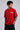 Red oversized t-shirt with 'PROJECTOR HANUMANJI' graphic design of a warrior monkey god and 'POPCASE' logo, worn by a man.