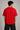 Couple wearing matching red oversized Hot Wheels t-shirts and black bottoms, standing on stairs. Feature iconic Hot Wheels logo.