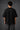 Couple wearing black Iron Man Jarvish oversized t-shirts. Man's back shows "IRON MAN" logo. Woman's front shows Iron Man arc reactor logo. Dark grey background.
