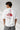 Model wearing a white POP-FROM-THE-NORTH oversized t-shirt with a small red logo on the chest, styled with black cargo pants, showcasing a relaxed streetwear fit. - white