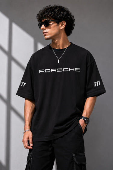 Beige oversized t-shirt featuring a vibrant green Porsche 911 RS RAWK graphic and 'Drifting Club' text. Mockup highlighting premium cotton fabric and stitching details.