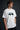 Model wearing white POPCASE Sir Lewis Hamilton oversized t shirt with Still We Rise 44 graphic and signature on chest