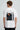 Model wearing white POPCASE Sir Lewis Hamilton oversized t shirt with Still We Rise 44 graphic and signature on chest
