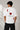 Man wearing a white oversized t-shirt with a large red Ace of Hearts graphic and 'pretty lucky' text on the back. Streetwear fashion.
