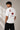 Man wearing a white oversized t-shirt with a large red Ace of Hearts graphic and 'pretty lucky' text on the back. Streetwear fashion.