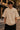Person wearing a beige t-shirt with '911' logo on a street.