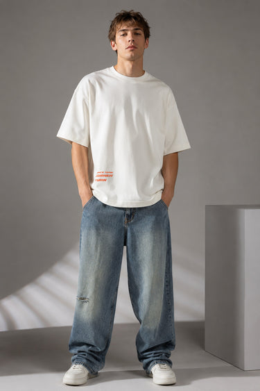 Red oversized t-shirt with 'Drift' graphic print in white and abstract black and yellow brush strokes. Focus on fabric texture and crew neckline.