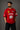 Close-up of a red Ferrari oversized t-shirt featuring the iconic yellow prancing horse logo and 'Ferrari 93' graphic. The fabric has a premium, textured look, showcasing high-quality print and material.