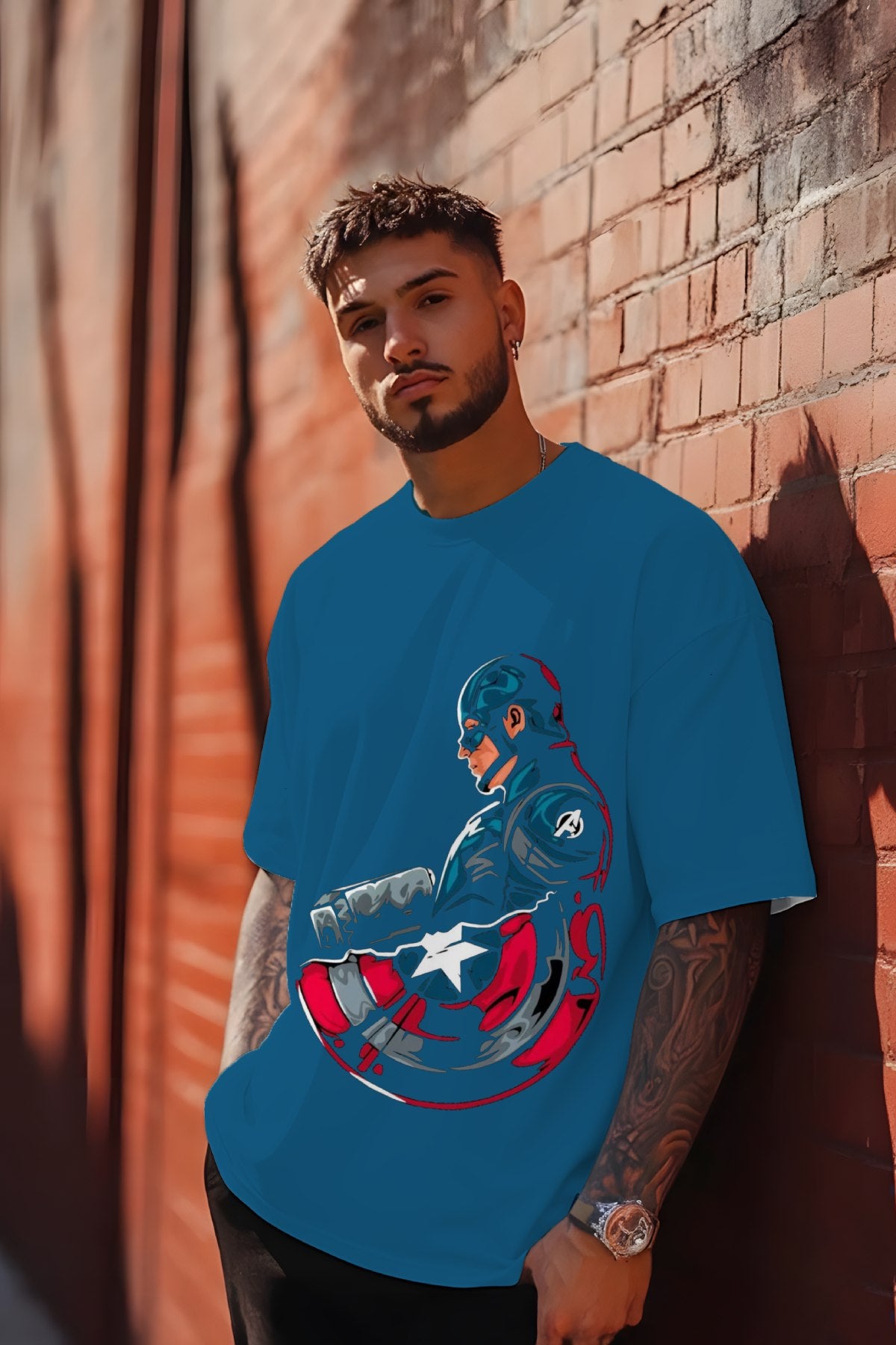 Man wearing a blue t-shirt with a superhero design against a brick wall.