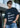 Man wearing a black t-shirt with '1% Better Every Day' text, standing outdoors.