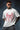 Man wearing a white t-shirt with a red spider graphic and text on a dark background