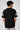 Person wearing a black t-shirt with 'NY' and number '23' on a plain background