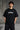 Black oversized t-shirt featuring a detailed white blueprint and a silver Nissan Skyline R34 with blue racing stripes graphic. Includes text 'The Nissan Skyline GTR'.