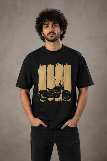 Back view of a man wearing an ENFIELD DESIGN black oversized t-shirt against a textured grey background. Features relaxed fit and premium cotton. - black