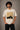 Back view of a man wearing an ENFIELD DESIGN black oversized t-shirt against a textured grey background. Features relaxed fit and premium cotton. - beige
