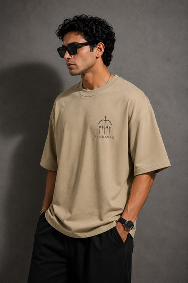 Model wearing a beige POPCASE 5 Pandav oversized t-shirt featuring a large graphic of 'Pandav' in Hindi, '05', and warrior icons. Premium streetwear.