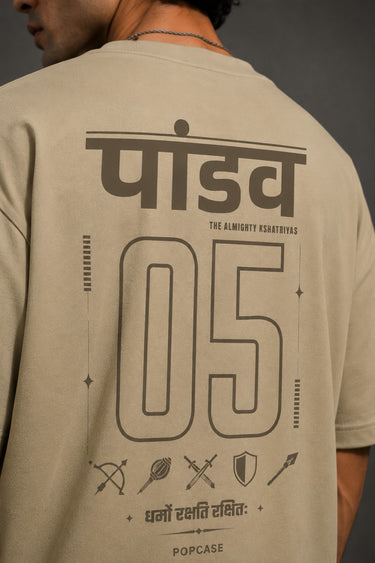 Model wearing a beige POPCASE 5 Pandav oversized t-shirt featuring a large graphic of 'Pandav' in Hindi, '05', and warrior icons. Premium streetwear.