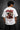 White oversized t-shirt with a bold graphic of the warrior Abhimanyu in front of a chariot wheel. Text includes "Made For War" and "Abhimanyuh" in Hindi. Detailed fabric information and care instructions are shown. - white