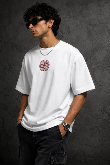 White oversized t-shirt with a bold graphic of the warrior Abhimanyu in front of a chariot wheel. Text includes "Made For War" and "Abhimanyuh" in Hindi. Detailed fabric information and care instructions are shown.
