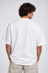 White oversized tshirt with red graffiti Ain't It text on chest and surreal pop art illustration below, drop shoulder boxy fit, men India