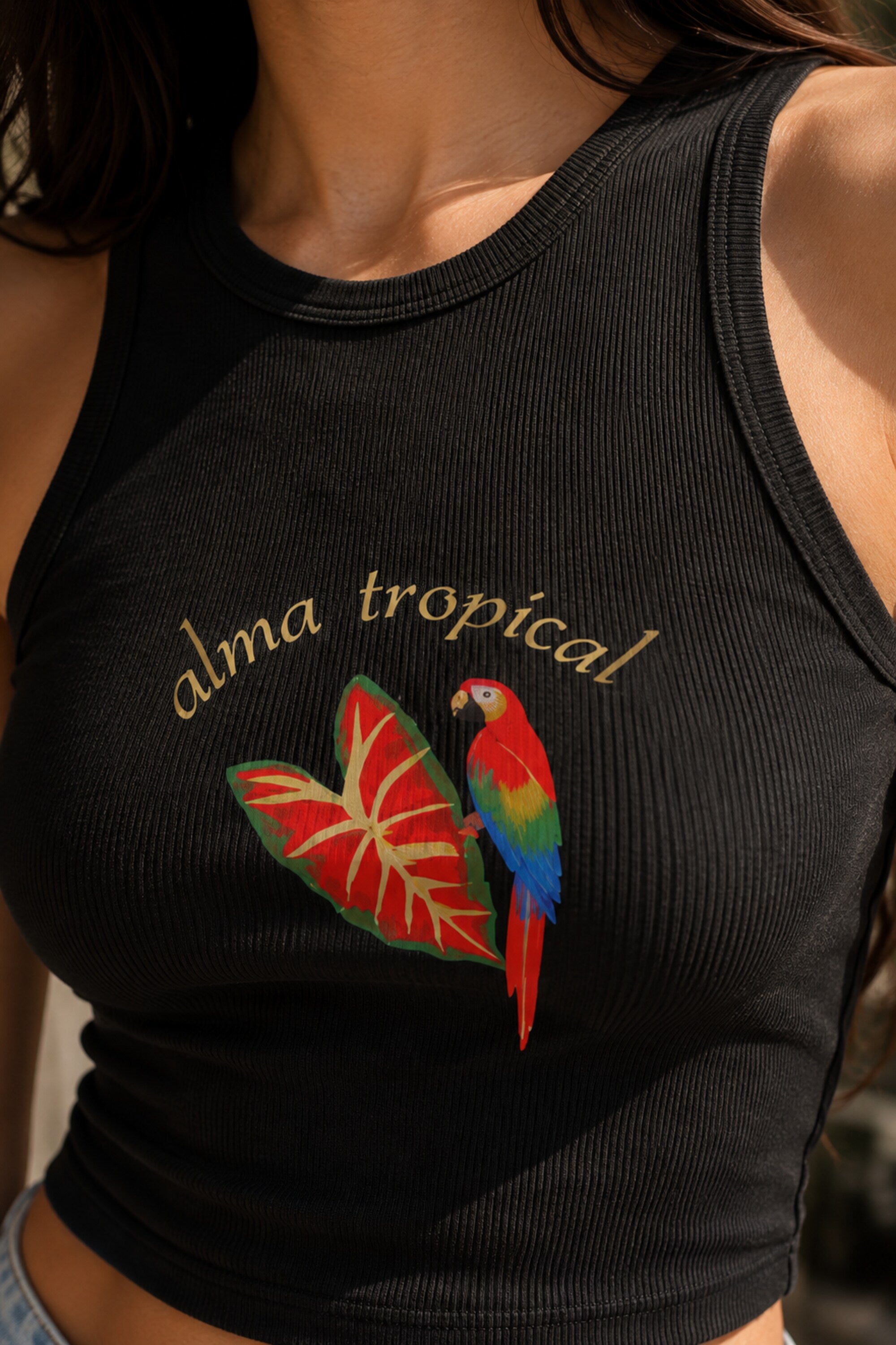 Black ribbed racerback crop tank top with alma tropical gold script and colorful macaw parrot tropical leaf graphic DTF print