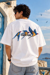 White oversized tshirt with vibrant macaw parrot bird illustration in blue yellow and green on left chest, drop shoulder boxy fit, men India