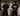 Man wearing a white oversized BMW M "530i E60" graphic t-shirt and black baggy jeans, standing against a textured concrete wall. - black